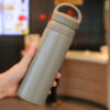 Grey stainless steel thermos bottle with matte texture